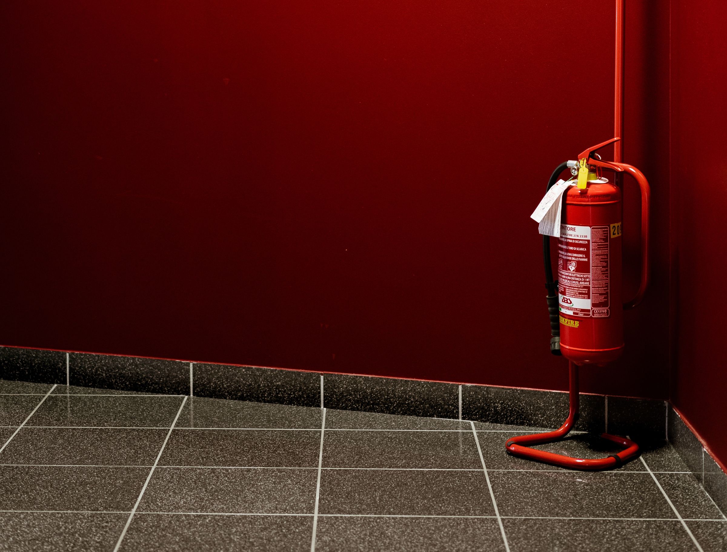 Feuerlöscher vor einer roten Wand