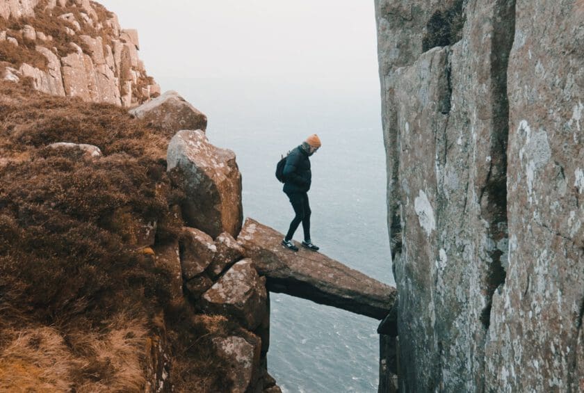Mann wagt sich auf einen vorspringenden Felsen