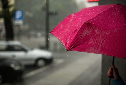 Pinker Regenschirm in einer verregneten Stadt
